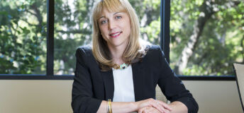Andrea Auerbach of Cambridge Associates sitting at a table with trees in background