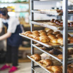 Fresh French Bread and croissants in a bakery in cooling rack