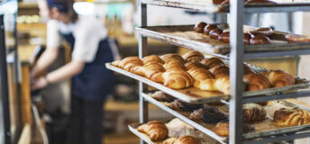 Fresh French Bread and croissants in a bakery in cooling rack