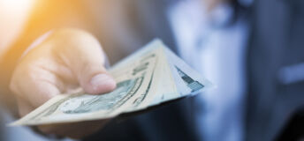 Businessman holding USD banknote for payment.US dollar is main and popular currency of exchange in the world. Investment and saving concept.