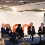 Panellists at IPEM Cannes speaking from a stage