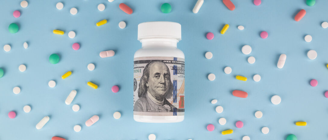A bottle of pills with a dollar bill wrapped around it on a blue background with drugs scattered around it